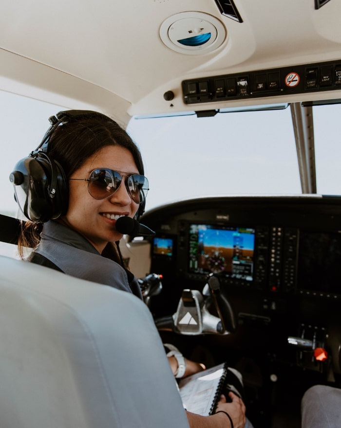 A student pilot smiling at the camera from the cockpit